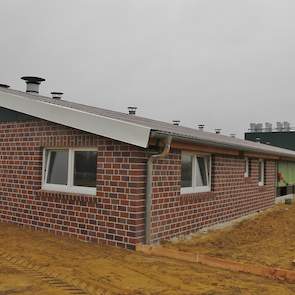 De voorgevel van de stal is gemetseld. De rest van de stalmuren bestaat uit prefab elementen. Tijdens het maken van de foto’s op dinsdag 1 november moet de vrije uitloop nog worden in gezaaid met graszaad. Alle erfbetreders die de stal willen betreden moe