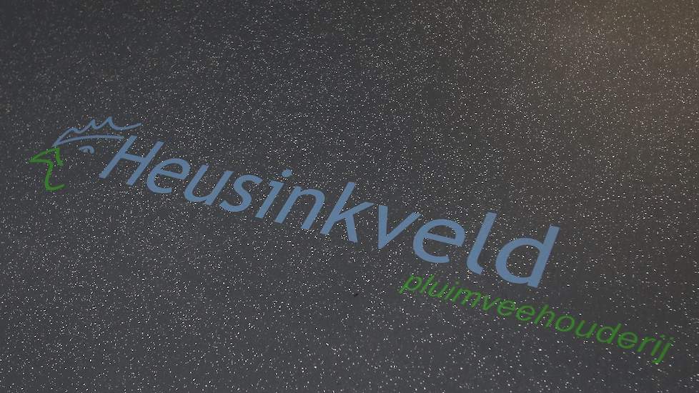 Op de vloer in het voerlokaal staat het logo van Heusinkveld pluimveehouderij.