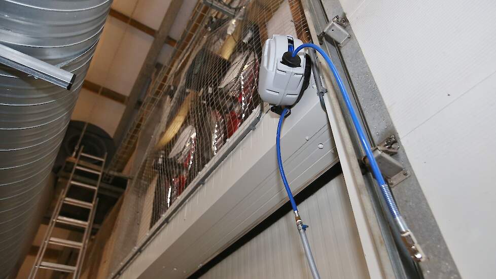 Bij de ventilatietoren hangt een hogeluchtdrukslang die Nies wil gebruiken om de ventilatoren na de ronde stofvrij te maken.