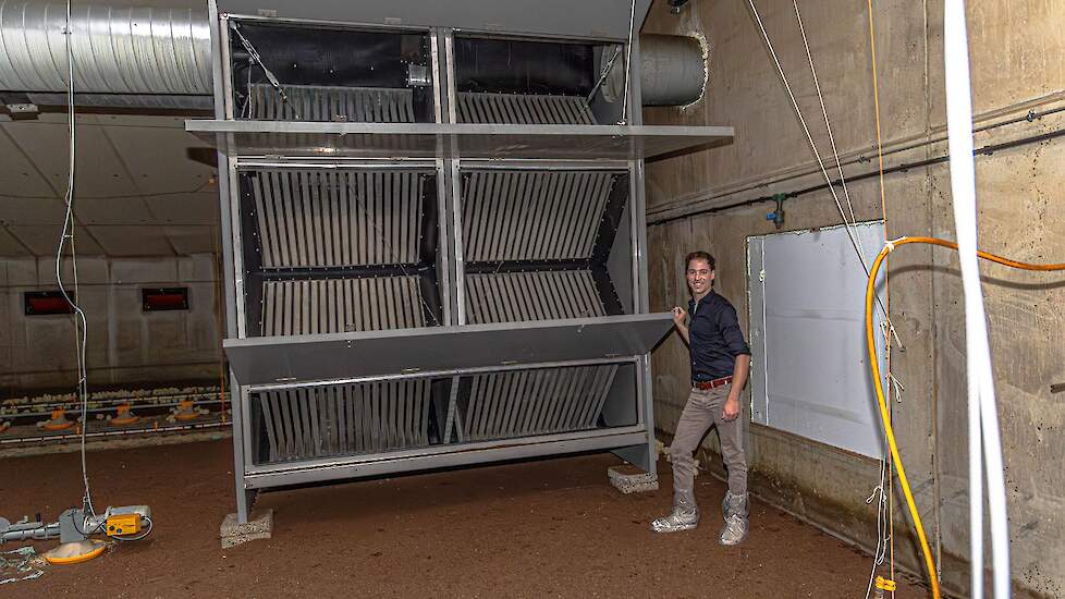 Vleeskuikenhouder Paul Verhoef bij de door hem ontwikkelde warmtewisselaar.